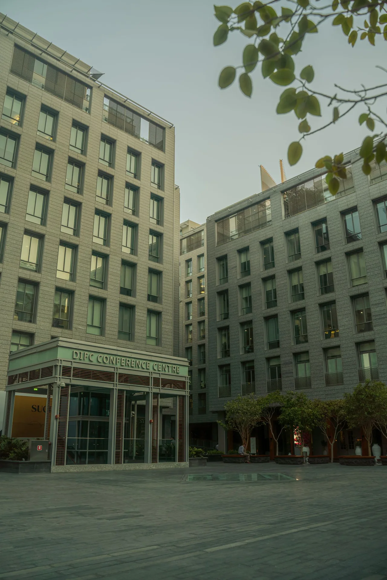 Stone and glass office buildings around the DIFC Conference Centre courtyard in Dubai