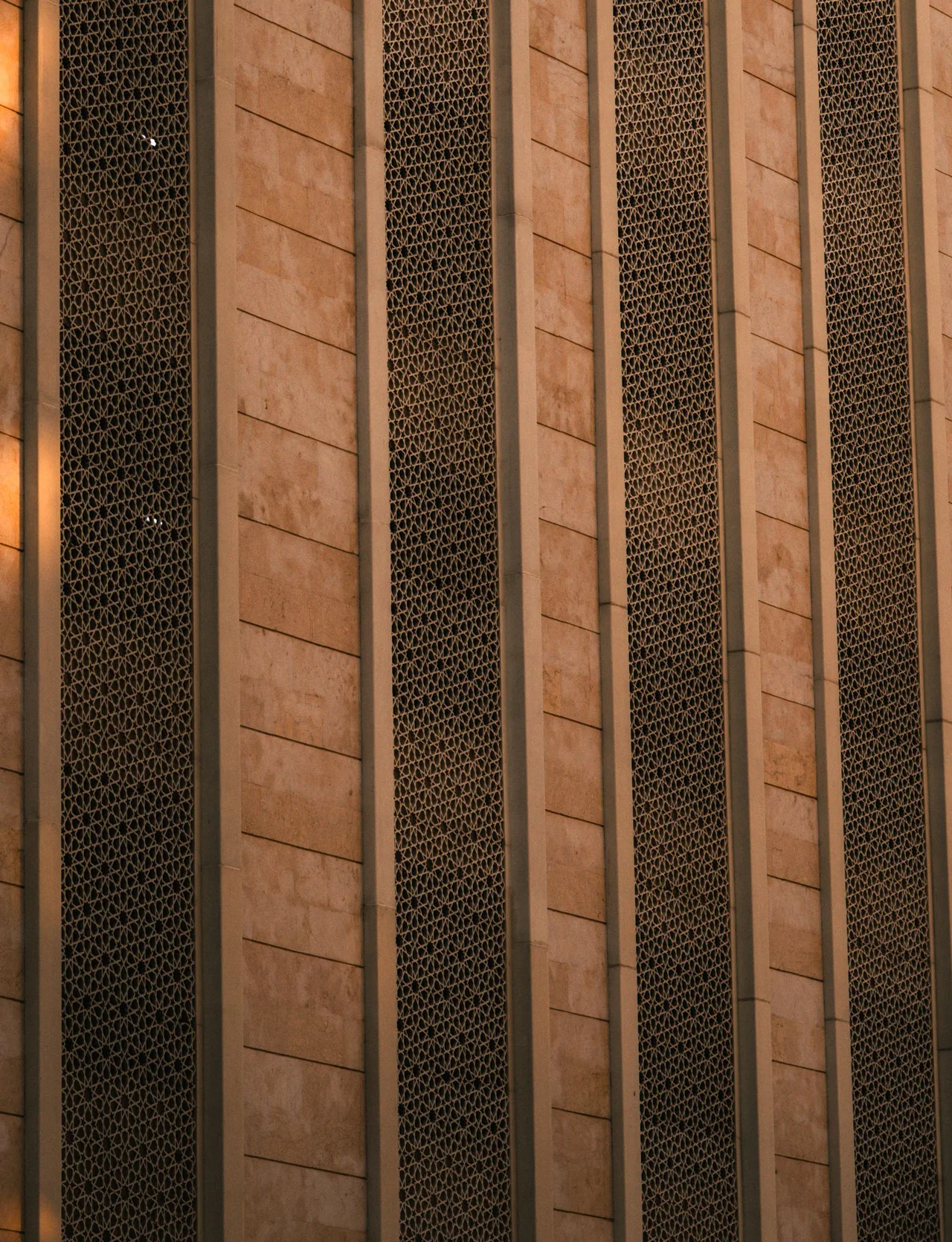Geometric screens and stone facade in Dubai, photographed in natural light